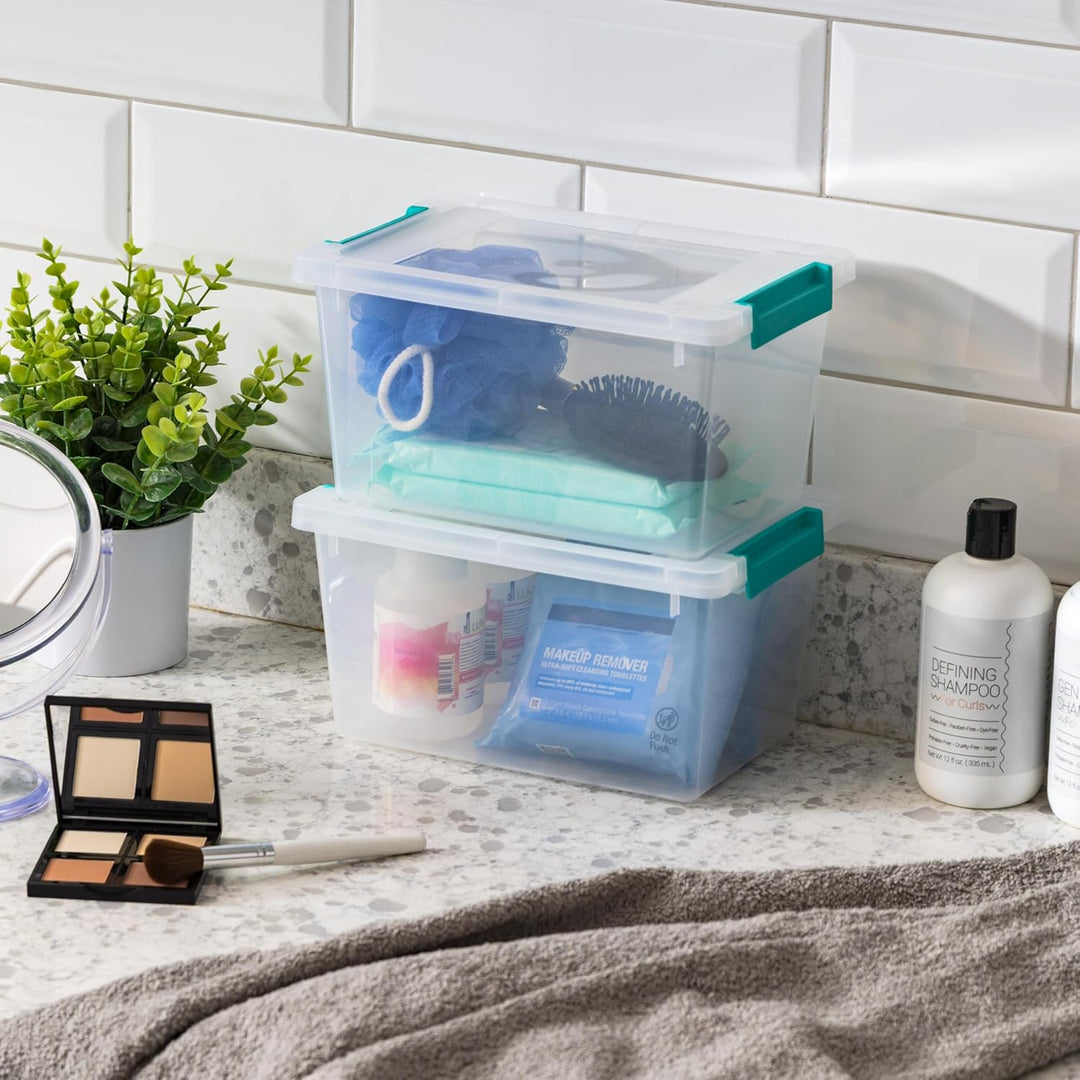 Stack of clear storage bins with green handles on a bathroom counter with toiletries.