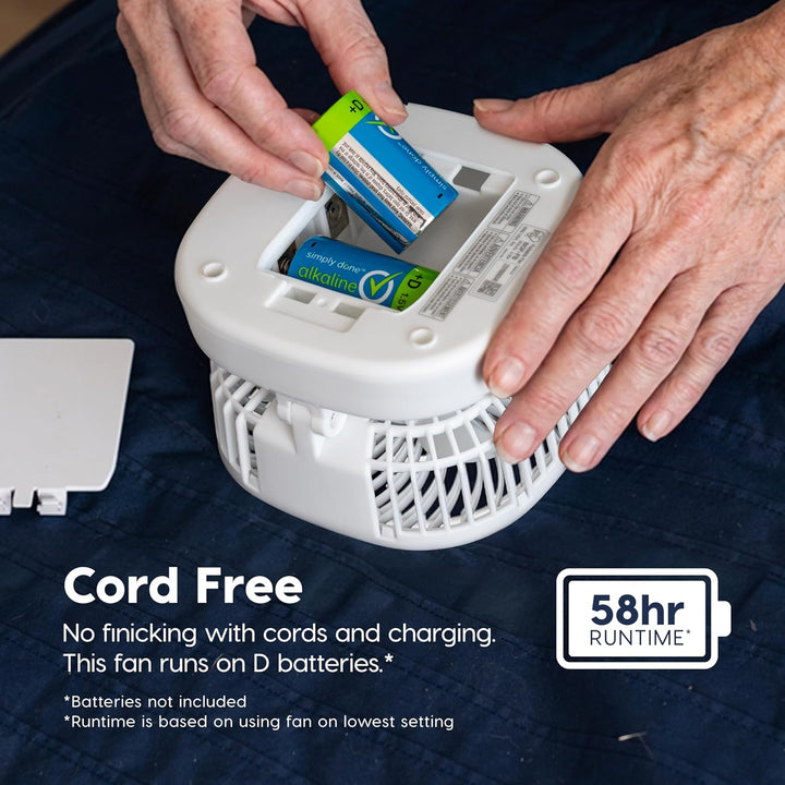Person installing batteries into a cord-free fan on a dark blue background