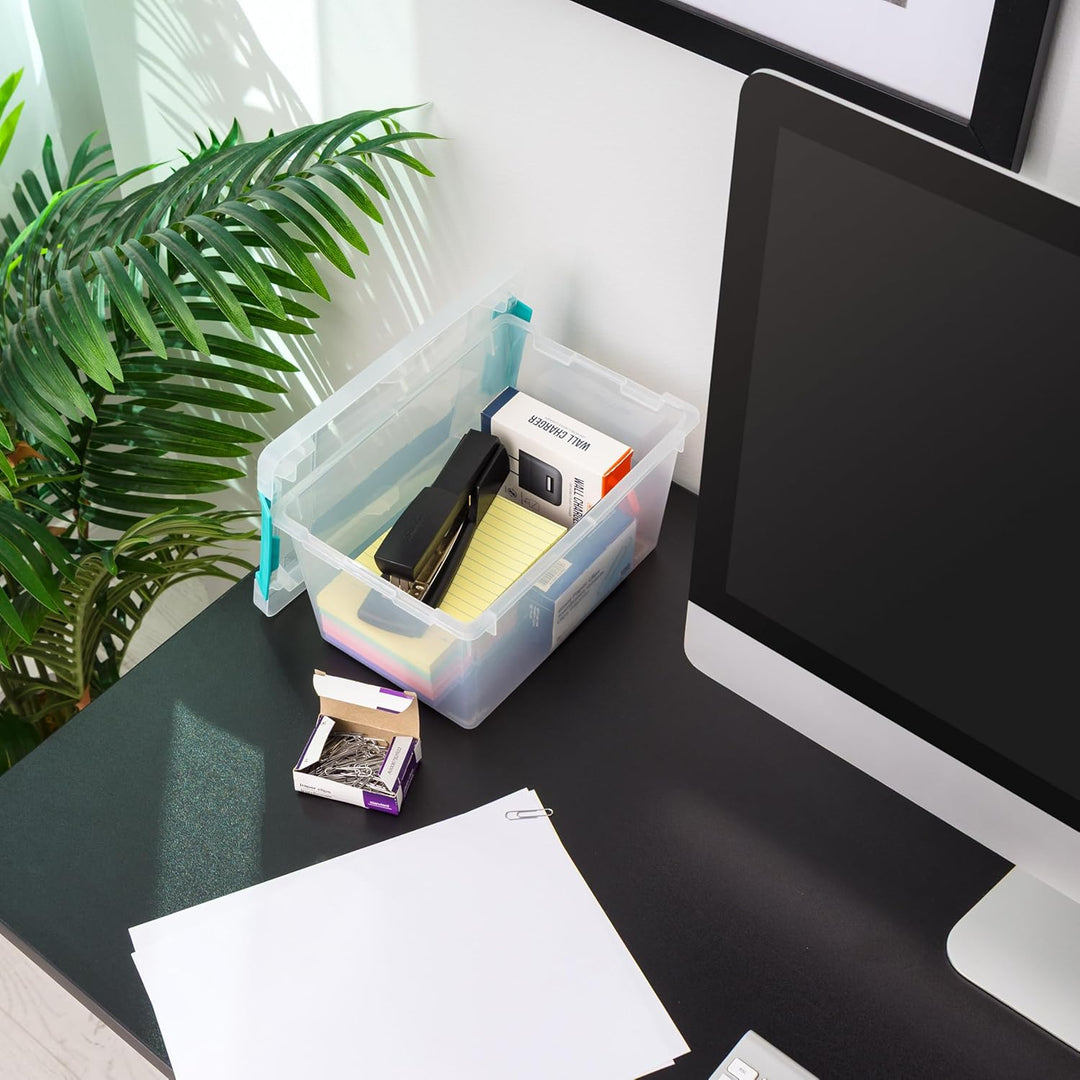 Clear storage container on a desk with office supplies next to a computer monitor.