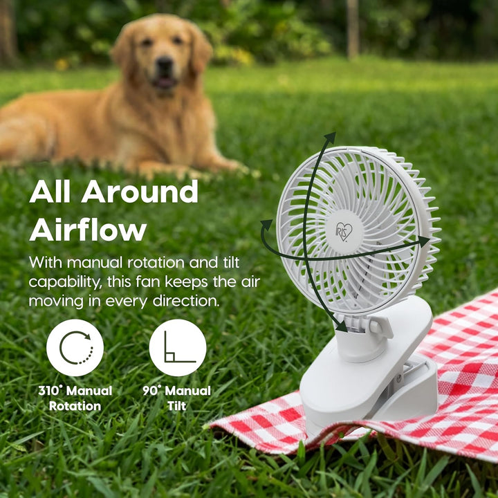 Portable fan on a checkered blanket with a dog in the background