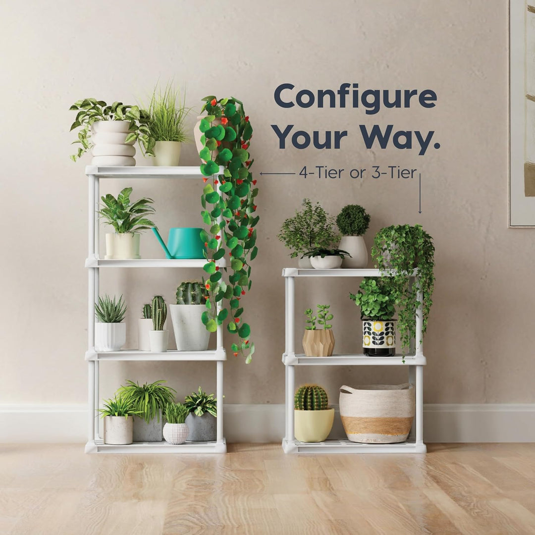 White shelving units with various potted plants against a beige wall.
