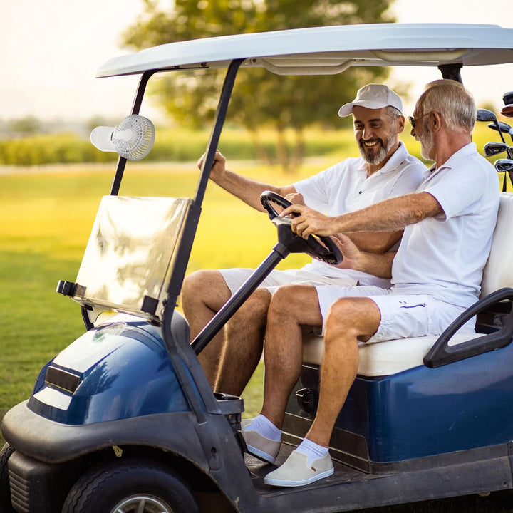 Two men in a blue and white golf cart on a golf course