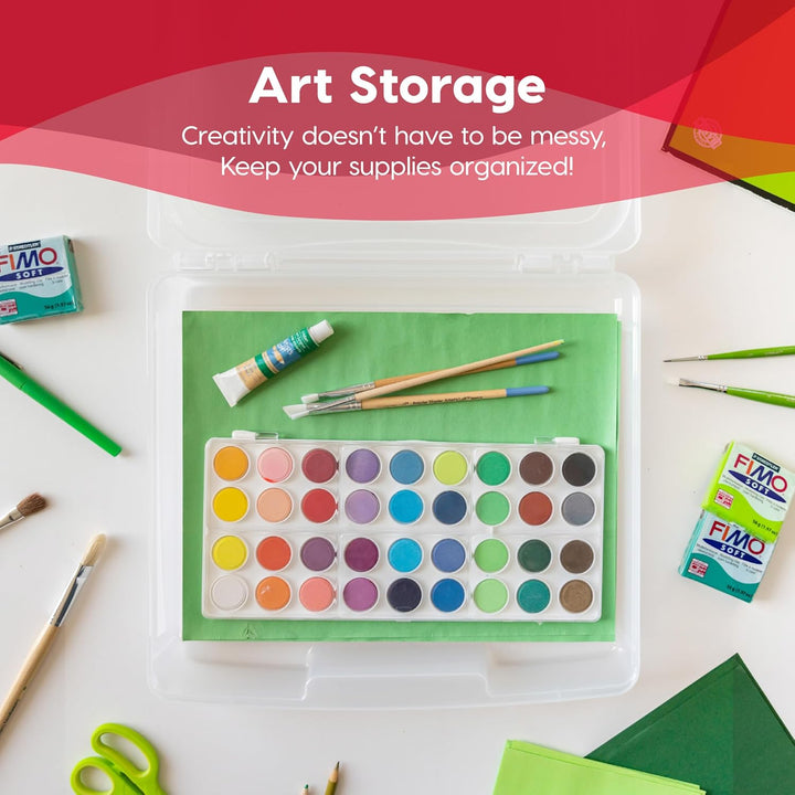 Art storage container with watercolor palette, brushes, and FIMO clay on a red background